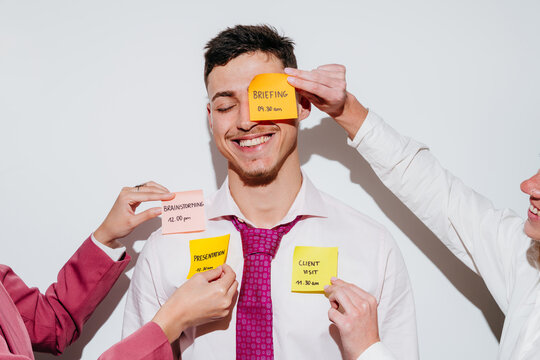 Happy man smiling with sticky notes for different work tasks