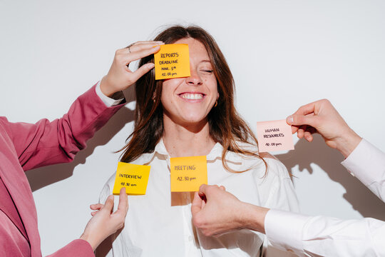 Happy woman smiling with sticky notes for different work tasks