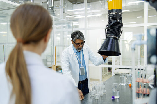 Two scientists young woman and Indian man in real laboratory