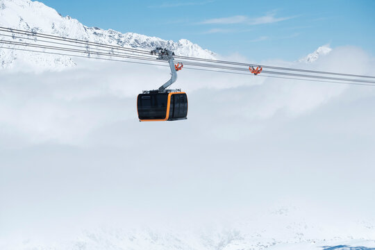 Massive cable car cabin in Tyrol with snowy mountains and fog 