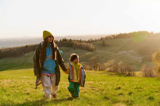 Mother and child walking in sunset meadow