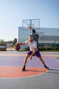 Male athlete playing streetball in summer