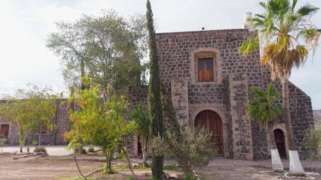 Explore Santa Rosalia mission in Baja California Sur, surrounded by desert, mountains, and a lush oasis bathed in afternoon light.