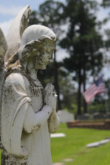 Obraz premium Old Angel Statue With American Flag in Background Rural East Texas Cemetery