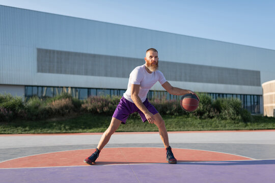 Bearded sportsman practicing dribbling movement