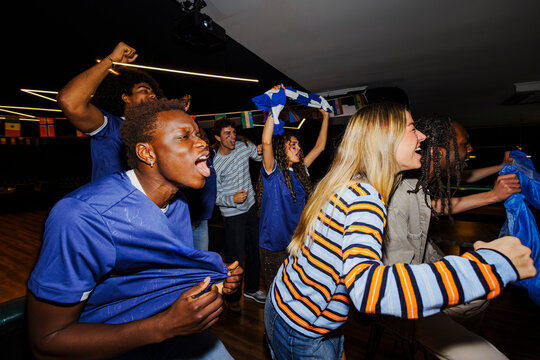 Group of friends cheering for sports team