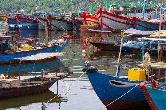 Colorful fishing boats moored next to one another in a coastal harbor