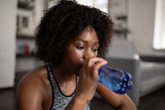 African American sportswoman drinking water