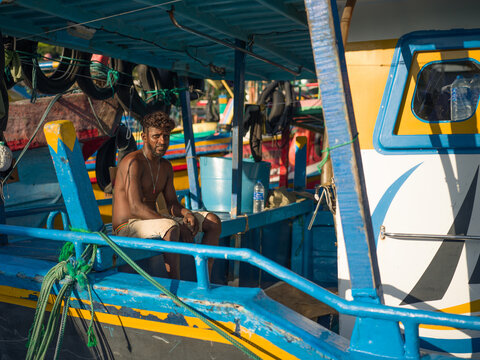 Fisherman Sits on Fishing Boat in Harbor in Mirissa Sri Lanka