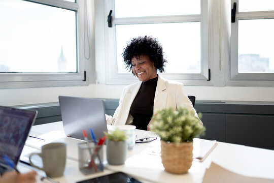 Happy black businesswoman working on laptop in office