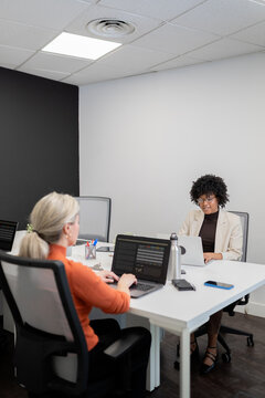 Business women working on laptops in modern office