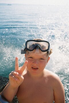 Child in a mask by the sea
