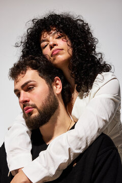 Couple takes a portrait with relaxed expressions and close embra
