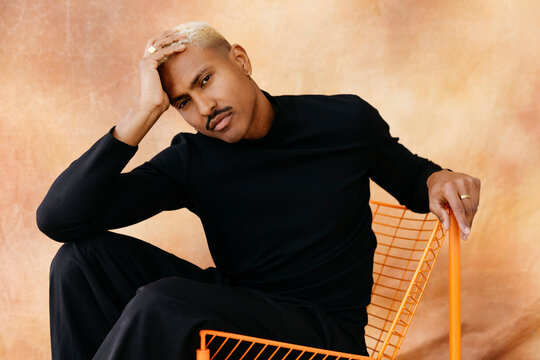 Man sitting confidently in orange chair