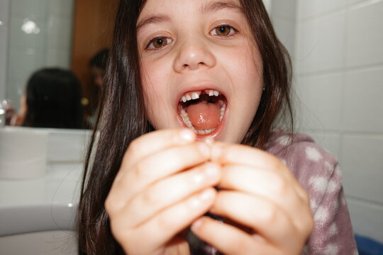 Happy Child Shows Lost Tooth in Bathroom. UGC