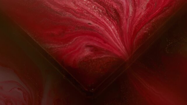 Ink pour. Glass cube angle. Blur red yellow purple color geometric texture vibrant droplets pour on abstract acrylic art background.