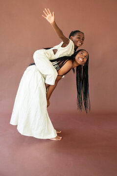 Daughter Rides on Mother's Back in a Fun Indoor Setting