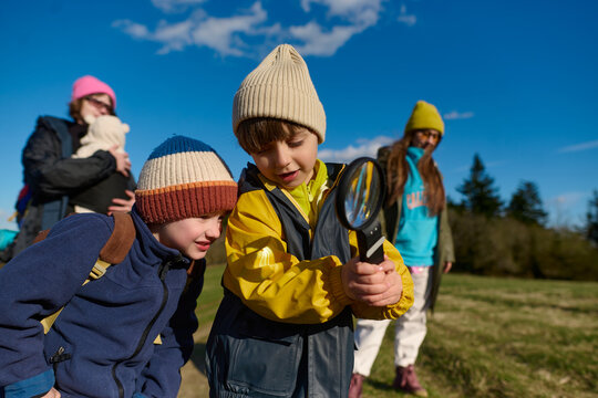 Children exploring nature with magnifying glass