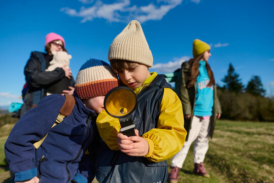 Children exploring nature with magnifying glass