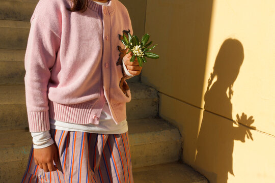 Child Holds a Flower on Steps 