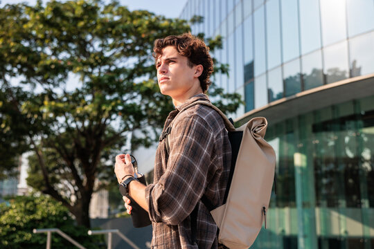 Man with backpack holding water bottle in extreme urban heat
