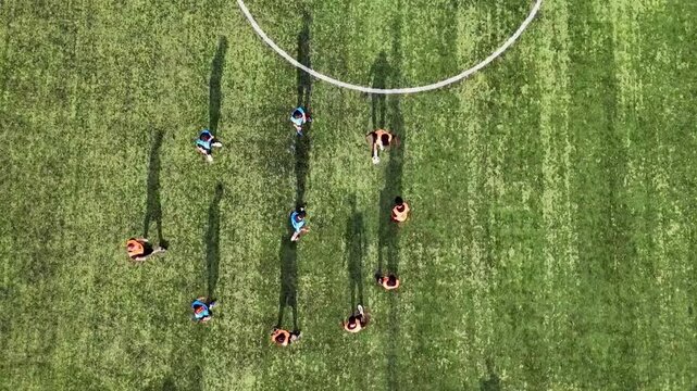 Before the match starts, the footballers gather in a circle to practice tackling the ball as a short warm-up