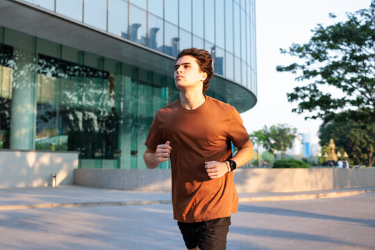Man jogging outdoors in city under sunny conditions