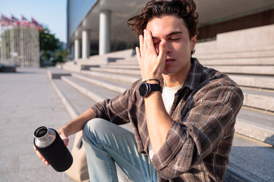 Exhausted Man Hydrating During Extreme Summer Heatwave