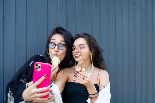 Two stylish friends taking a selfie with ice cream 