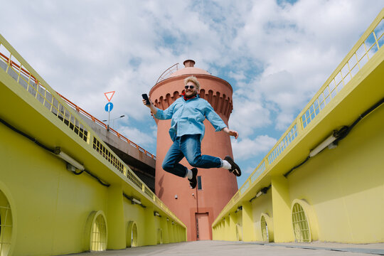 Happy man jumping on yellow bridge walkway