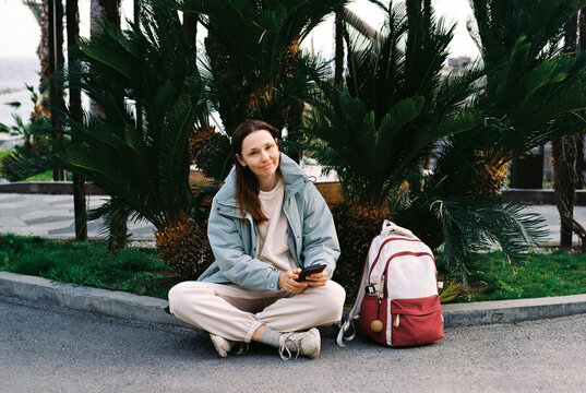 Smiling middle-aged woman waiting bus while travelling.