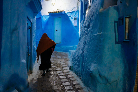 An anonymous woman walks in the alleys of a village