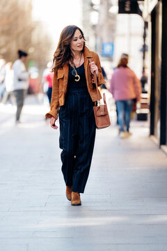 Woman walking city street wearing street style fashion