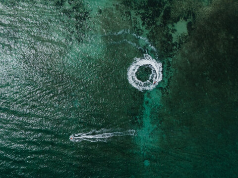 Jet skis creating wake patterns in clear water
