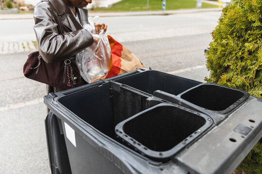 Woman Sorting Recycling in Multi-Compartment Outdoor Bin