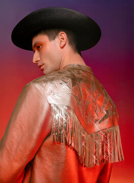Man in a gold cowboy outfit with fringe jacket and cowboy hat back