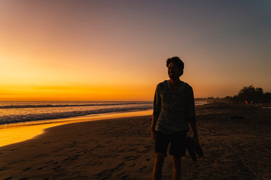 Man enjoying sunset walk on tropical beach