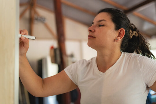 Woman writing on whiteboard communicating ideas and brainstorm