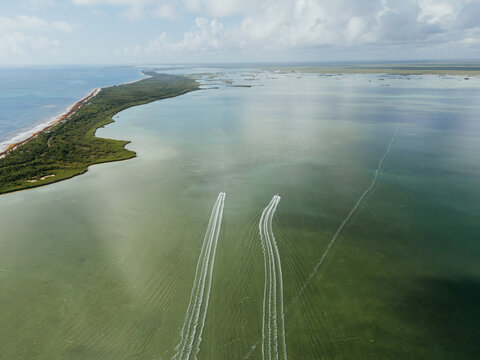 Two boats leaving wakes on shallow lagoon water