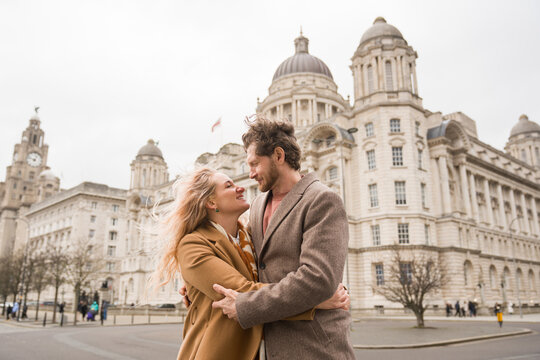 Couple Enjoys Time Together Near Historic Buildings in Liverpool