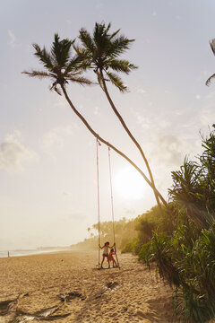 Children Playing on Beach Swing at Sunset. Sri Lanka