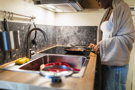 Woman Wrapped in Blanket Cooking in Small Modern Kitchen