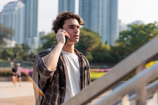 Man with backpack on phone call in city appearing concerned