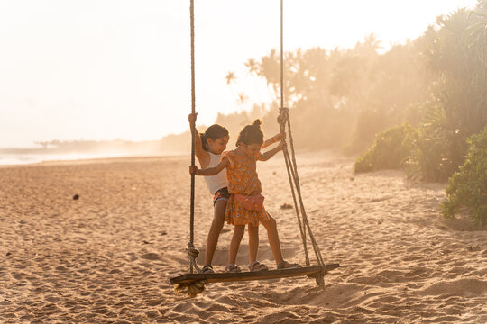 Children Playing on Beach Swing at Sunset. Sri Lanka
