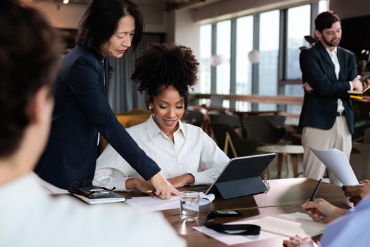 Diverse team collaborates on project in modern office space.