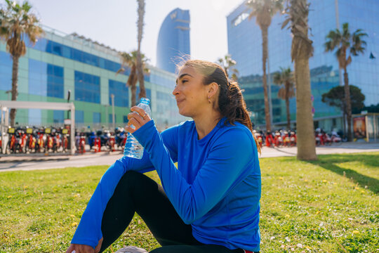 A woman drinks water from a bottle