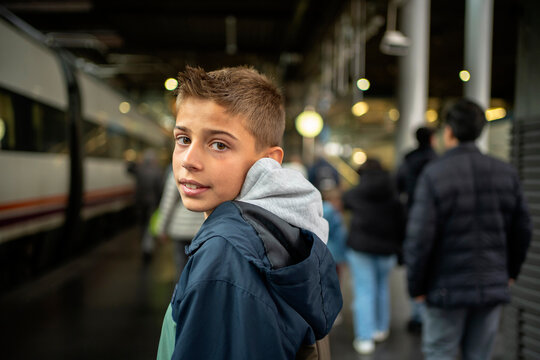 A boy Walking Through Busy Train Station.