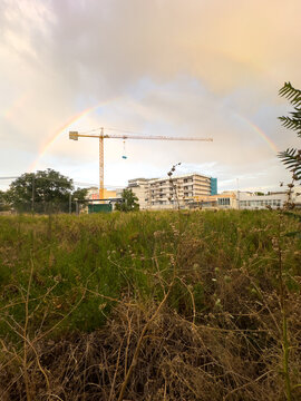 Construction Site With Crane and Rainbow in the Sky During Evening