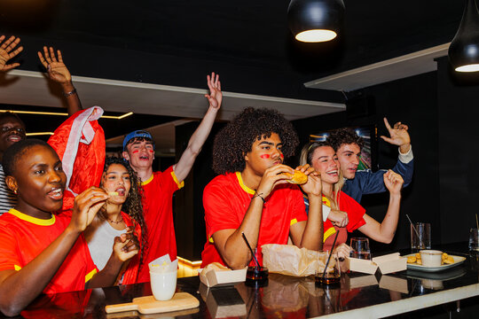 Friends celebrating viewing football sport in bar