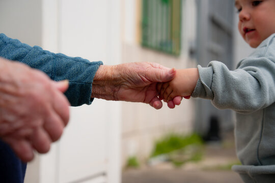 Grandmother holding toddler hand